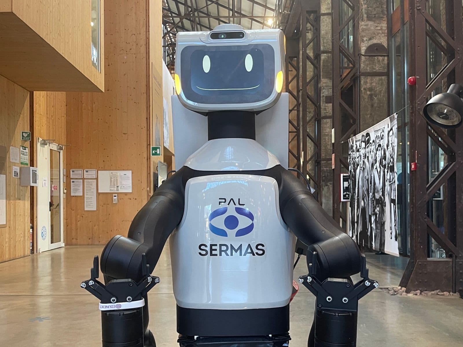 A big robot with a smiling face and a SERMAS logo.